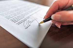 a man with a patented product signing a provisional application document to protect his products that have patents